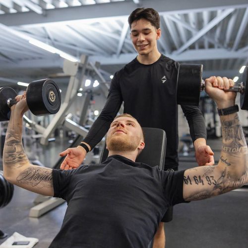 Zwei Mitglieder am Krafttraining mit Hanteln bei einer Übung im actiwita Remagen