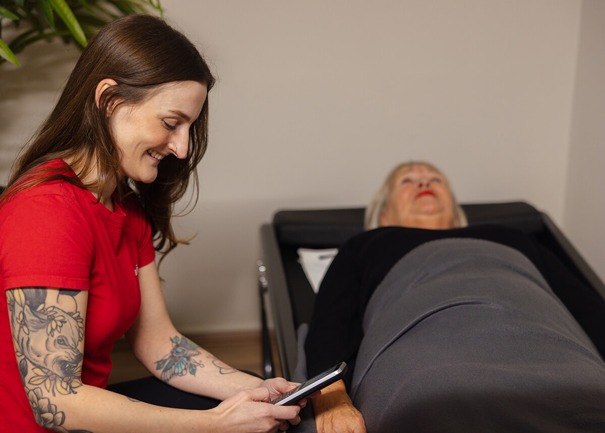 Mitgliederin mit Betreuung einer Trainerin auf einer Rückenmassage Ceragem Liege im actiwita Remagen